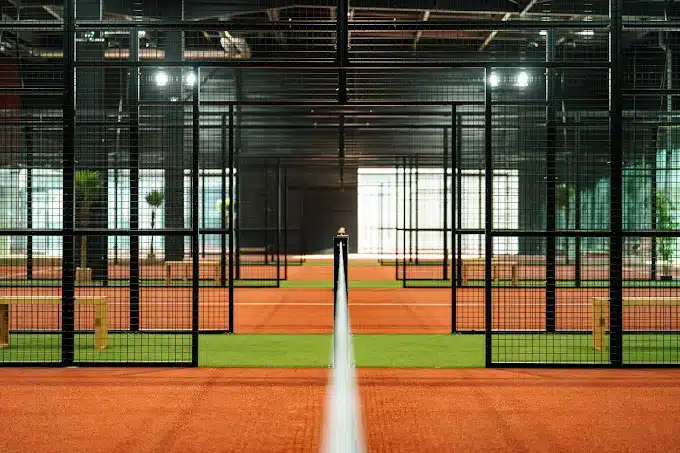 Terrain de padel indoor vu a travers le grillage vitre du Cocoon Padel Club a Rouen