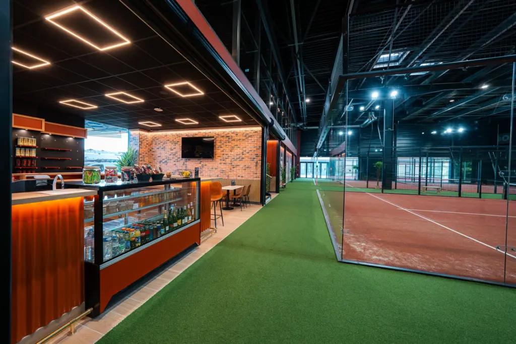 Comptoir bar avec boissons et snacks longeant les terrains de padel indoor du Cocoon Padel Club