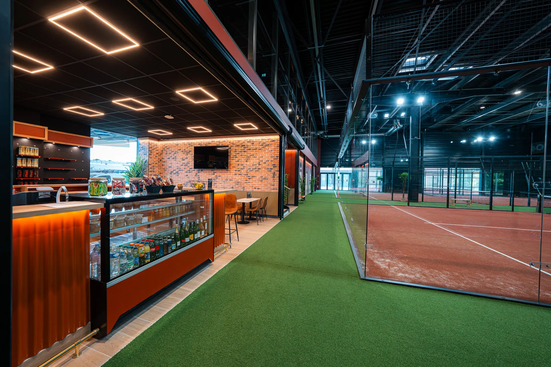 Comptoir bar avec boissons et snacks longeant les terrains de padel indoor du Cocoon Padel Club