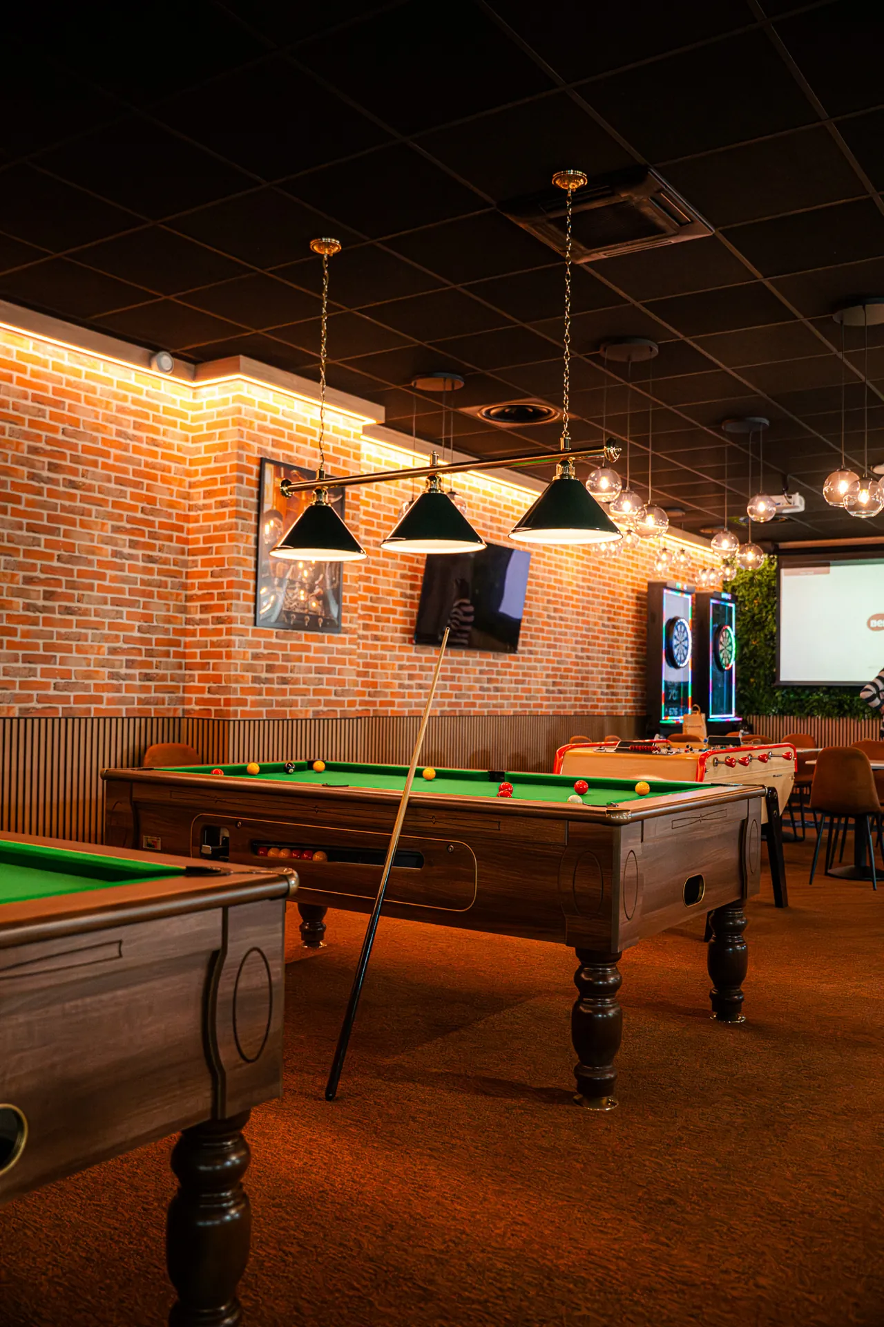 Espace de jeu du Cocoon Padel Club : tennis de table, baby-foot et bornes d'arcade
