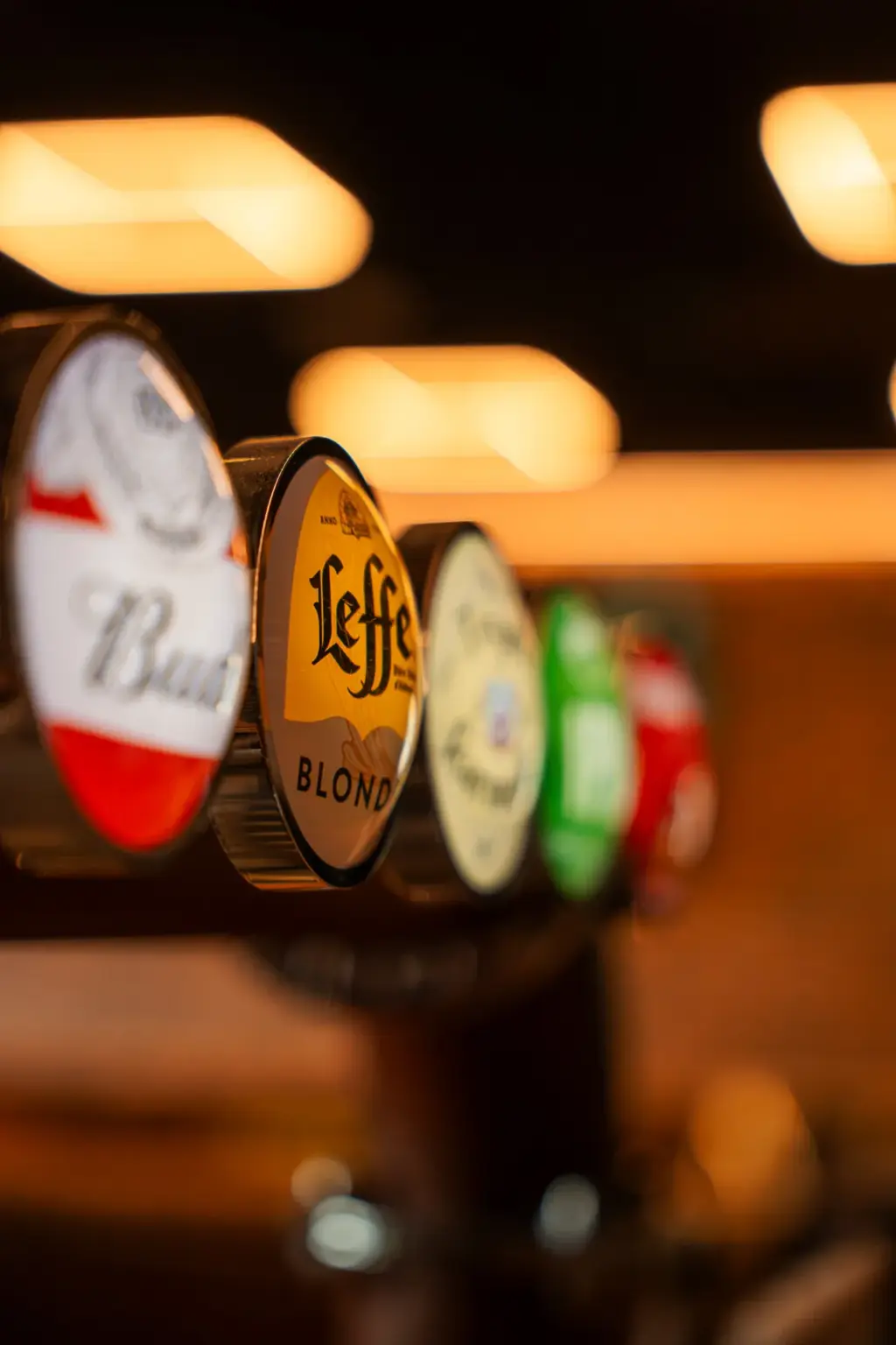 Rangée de becs à bière pression Bud et Leffe Blonde au comptoir du bar, Cocoon Padel Club à Rouen